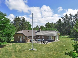 Feriehus med carport beliggende på en skøn over ugeneret naturgrund.