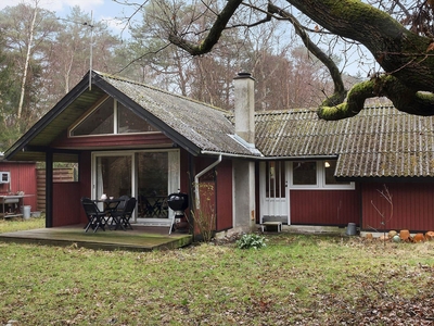 Midt i Ulvshale skov på en naturgrund finder du det her ældre træsommerhus.