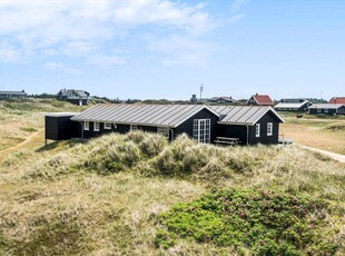 Velholdt træhus beliggende på en stor lyngbeklædt naturgrund.