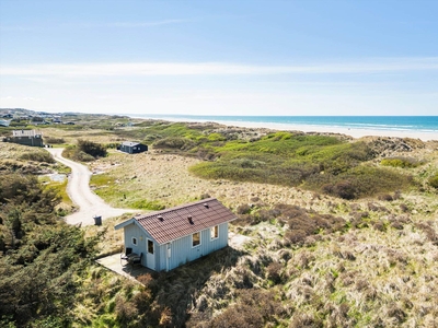 Lille, sødt sommerhus i første række til havet – perfekt til parferien