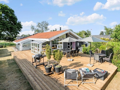 Skønt sommerhus med dejlig stor træterrasse samt aktivitetsrum med egen hjemmebiograf - tæt på havn og dejlig sandstrand i Juelsminde