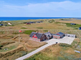 Højtbeliggende, arkitekttegnet feriehus direkte ved stranden.