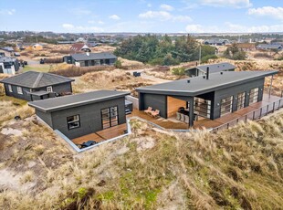 Meget hyggeligt sortmalet sommerhus beliggende 250 meter fra Ulvshale Strand.