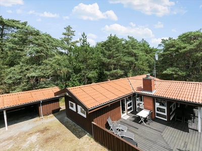 Indbydende sommerhus i træ med stor terrasse, tæt på god strand