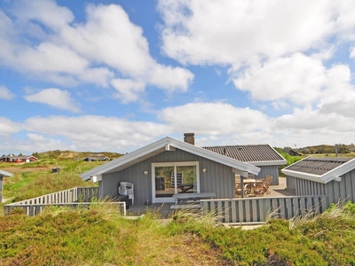 Feriehus beliggende på en kuperet naturgrund.