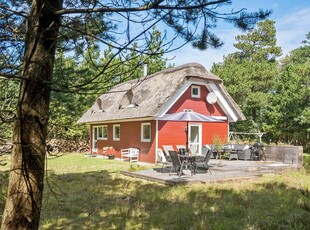 Flot rødt-hvidt stråtækt sommerhus på idyllisk og natursmukke Rødhus