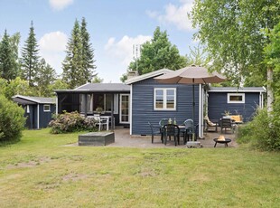 Sommerhus i træ med stor delvist overdækket terrasse