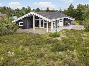 Charmerende træsommerhus i skønt naturområde tæt på den lange sandstrand ved Vejlby Klit.