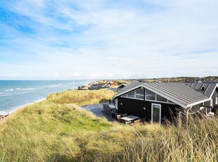 Oplev roen og harmonien i dette dejlige sommerhus, som ligger i første række til Vesterhavet på Harerenden 3 i Lønstrup