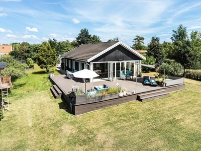 Lækkert sommerhus med stort glasparti, masser af plads og dejlig have midt i Kongsmark Strand.