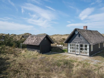 Stråtækt feriehus med garage og lille udestue.