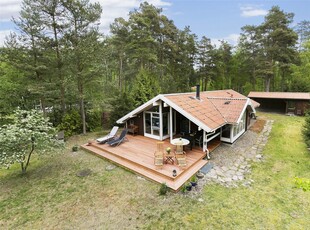 Indbydende sommerhus i træ. God grund med flere terrasser