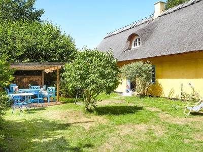 Skønt historisk sommerhus med stråtag og fantastisk overdækket terrasse.