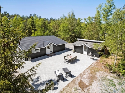 Indbydende og hyggeligt sommerhus i træ, med god naturgrund til børnene