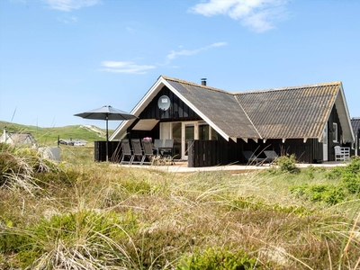 Klassisk træsommerhus med lys indretning og skøn adresse nær Vesterhavet