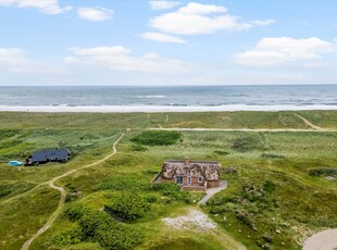 Stråtækt sommerhus i første klitrække ved Vrist Strand