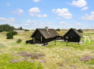 Sommerhus med stråtag, idyllisk naturgrund og rolig beliggenhed