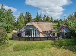 Stort og rummeligt murstenshus med stråtag og helt lukket terrasse