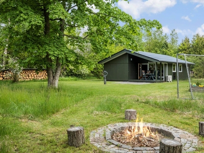 Hyggeligt træsommerhus med bålsted og terrasse på naturgrunden