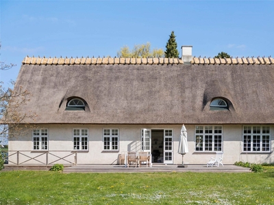 Idyllisk stråtækt ejendom - Råbylilles gamle skole fra 1860 - fredeligt beliggende i det maleriske landskab på Østmøn.