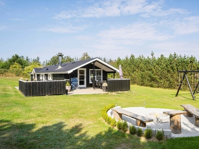 Lyst og indbydende træsommerhus på ugeneret naturgrund