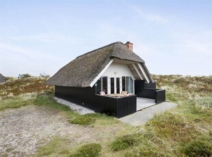 Idyllisk sommerhus med udsigt over storslået klitlandskab og Blåvand fyr